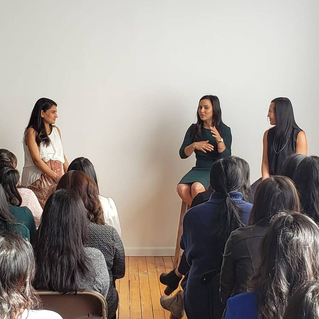 women speaking in front of audience
