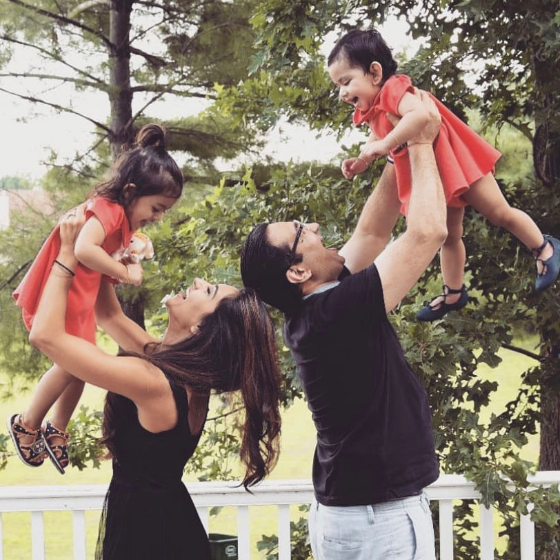 laughing man and woman holding up smiling children