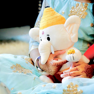 woman with mehndi holding ganesh plush